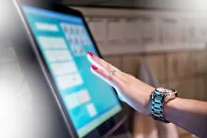 Bartender entering sale into point of sale terminal